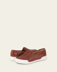 A pair of FRYE Mia Slip-On in Cognac Leather with a removable footbed and white soles on a neutral background.
