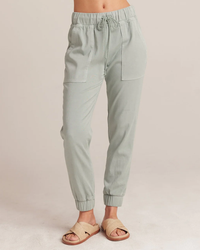 A pair of Bella Dahl Pocket Joggers in Oasis Green paired with beige sandals.