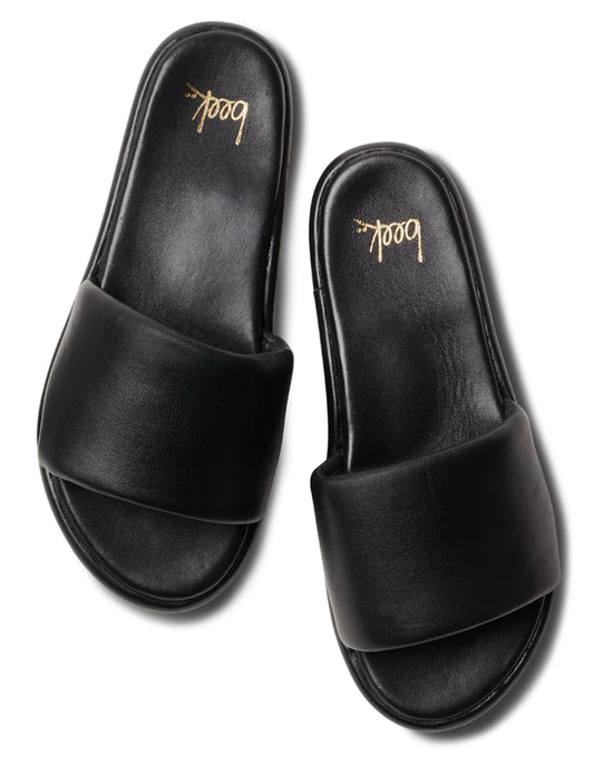 A pair of beek. Puffbird in Black leather platform sandals with gold text on the memory foam insole.