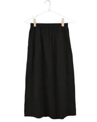 Everyday Skirt in Black by It is well LA on hanger against a white background.