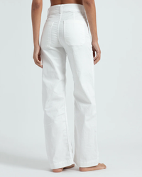 A person standing with their back towards the camera, wearing ASKK NY's Sailor Pant - Twill in Ivory.