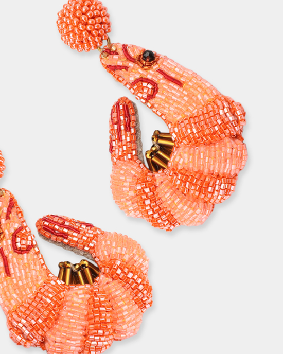 Pair of orange hand-made seed bead shrimp-shaped earrings by Olivia Dar against a white background.