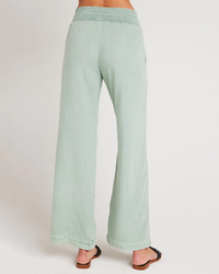 Woman wearing Bella Dahl's Smocked Waist Wide Leg Pant in Oasis Green, viewed from the side.