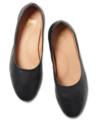 A pair of Swiftlet in Black ballet flats by beek., featuring black leather, memory foam cushion soles, tan insoles, and “loeff” printed in gold on the inside heel.