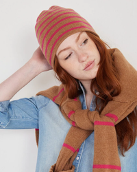 Woman wearing a Tate Cashmere Beanie in Toffee & Winter Pink Stripe from Not Monday and brown scarf with a denim jacket.