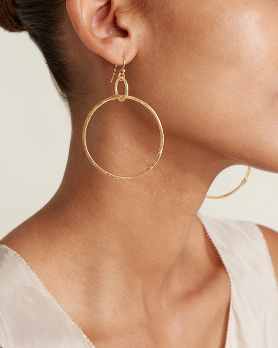 Close-up of a woman wearing a Chan Luu Rhiannon Hoop Earrings in Yellow Gold, focusing on the earring and her jawline.