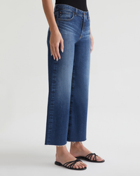 A person wearing AG Jeans' Saige Wide Leg Crop in Enigma and black strappy sandals against a white background.