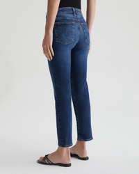 Person wearing AG Jeans Mari Crop in Havana and black sandals standing against a neutral background.