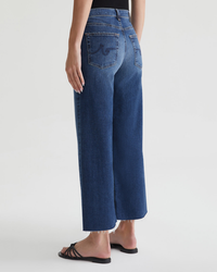 Woman wearing AG Jeans Saige Wide Leg Crop in Enigma and flip-flops, viewed from behind.