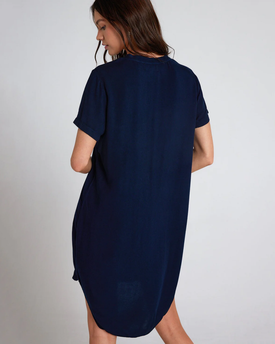 A woman in a navy blue, 100% Rayon, V-Neck Dress in Endless Sea by Bella Dahl seen from the back.
