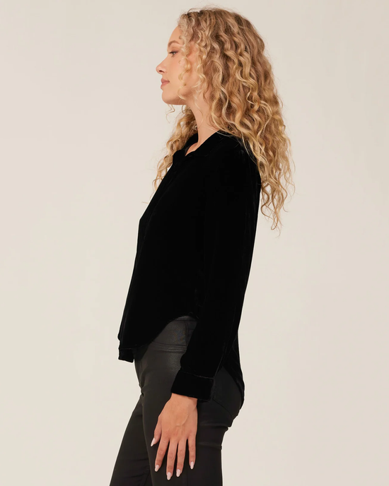 Profile view of a woman with curly hair wearing a Bella Dahl Long Sleeve Clean Shirt in Black and grey trousers.