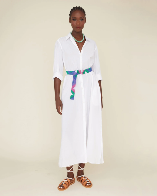 Woman standing in a white XiRENA Boden dress with a colorful belt and brown sandals, crafted from cotton poplin.