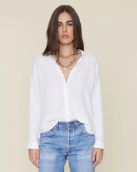 Woman wearing a XiRENA Scout L/S Shirt in White and blue jeans with a statement necklace.