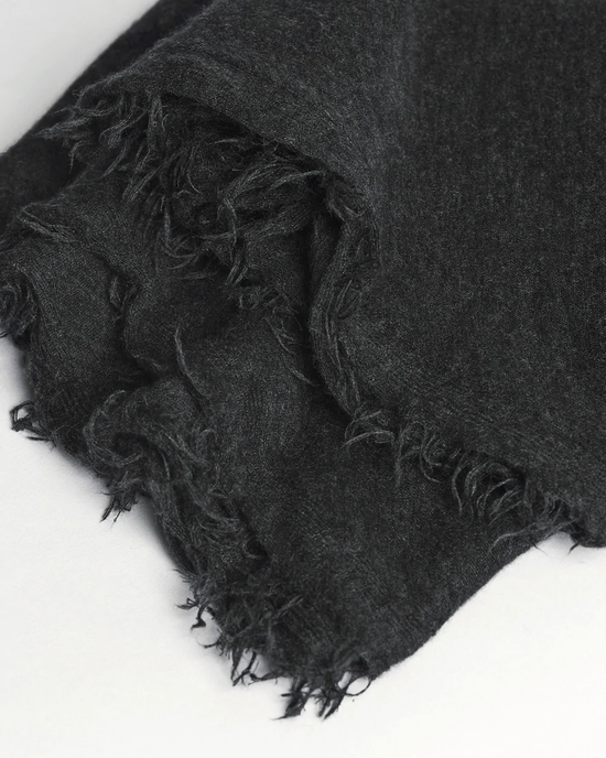 Close-up of a black, Grisal Love Cashmere Scarf in Charcoal, heirloom quality, frayed fabric texture.