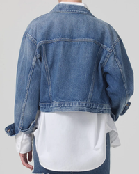 Person wearing a Citizens of Humanity Organic Denim Dulce Jacket in Brevity over a white shirt, viewed from behind.
