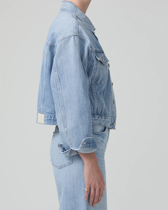 A side view of a person wearing a Citizens of Humanity Dulce Denim Jacket in Seaplane and organic denim jeans.