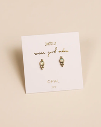 Pair of Tri Ball Studs - Fire Opal earrings by JaxKelly on a display card with the text "wear good vibes" and the stone type "opal" listed as "joy.