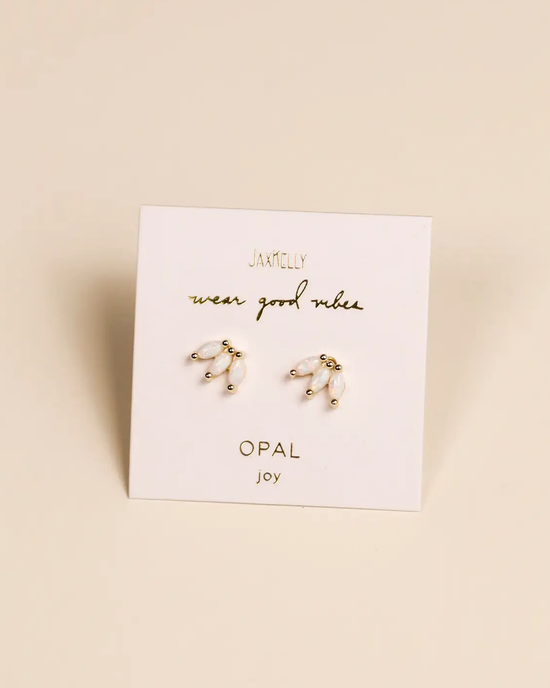 A pair of JaxKelly Opal Crown Stud - White earrings presented on a card with the words "wear good vibes, opal joy.