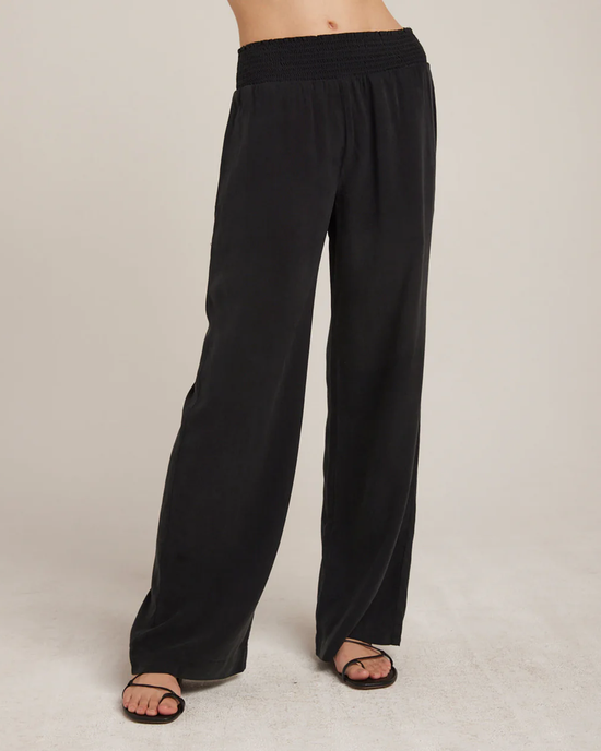 Black Bella Dahl Smocked Waist Wide Leg in Vintage Black pants paired with sandals on a model against a neutral background.