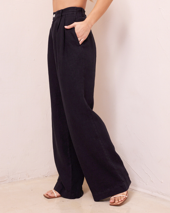 A person showcasing Bella Dahl's Pleated Wide Leg Trouser in Black with a hand on the hip.