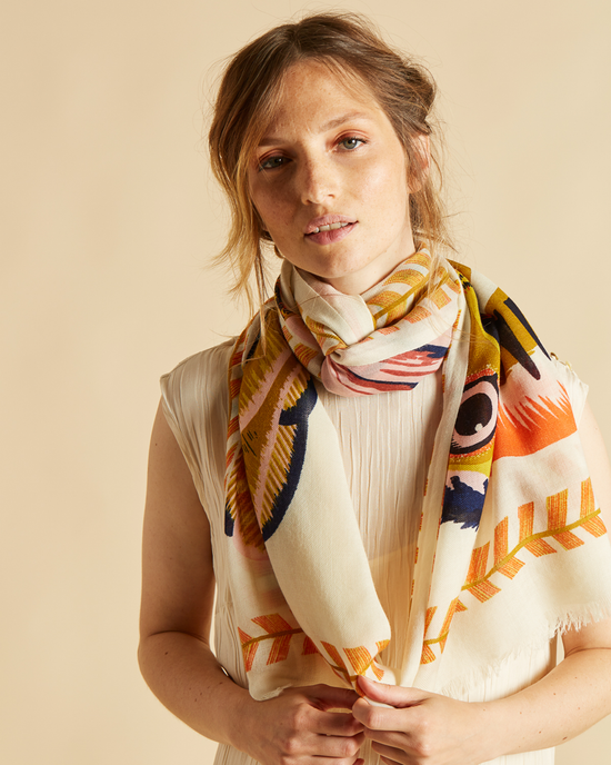 Woman wearing a colorful Inoui Editions Scarf 70 Toucan in White with a neutral background.