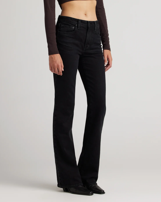 Woman wearing black Edwin USA Lark in Ramble jeans with 5 pocket detailing and a cropped top, against a gray background.