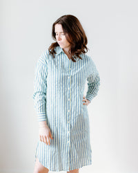 A woman in a Felicite Apparel lightweight cotton, Neon Yellow Stripe tunic dress looking to the side with a neutral expression.