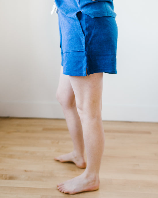 Person standing in blue 100% Cotton Hartford Timoe Shorts in Mykonos against a neutral background.