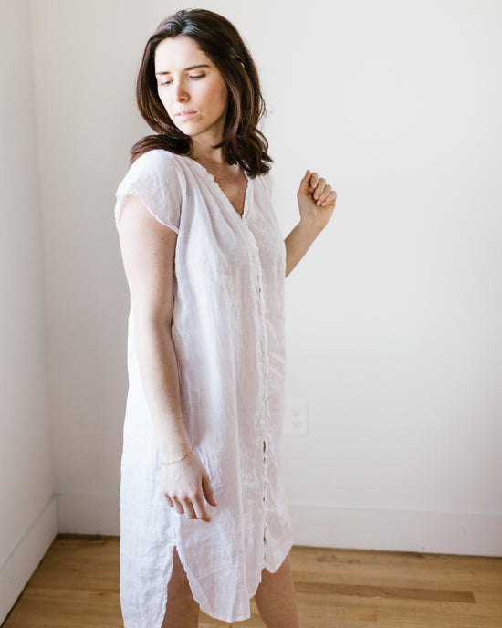 A woman in a CP Shades Lucy Dress w/o Pkts in White HW Linen Twill standing with eyes closed and a relaxed posture against a plain background.