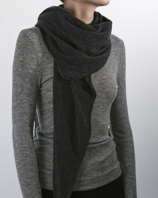 Woman wearing a grey turtleneck and an heirloom quality dark Grisal Love Cashmere Scarf in Charcoal.