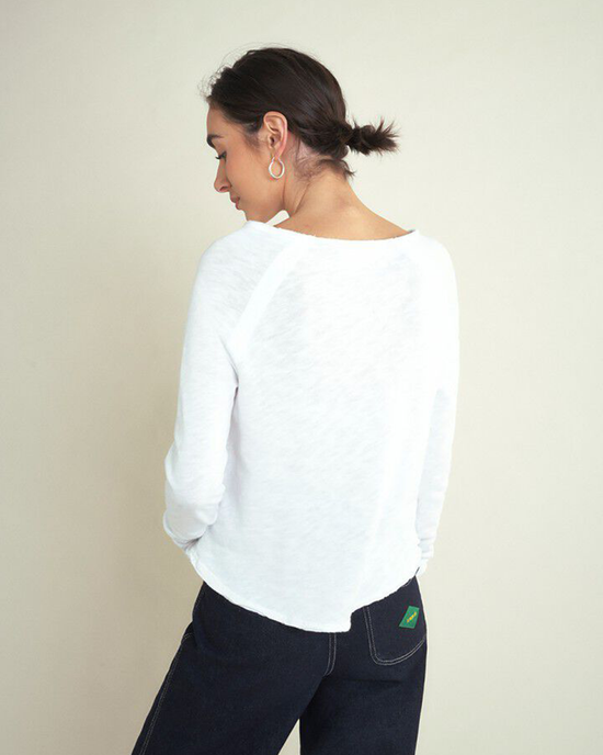 Woman in an American Vintage Sonoma L/S Scoop in Blanc organic cotton, long-sleeved scoop neck top and dark jeans facing away from the camera.