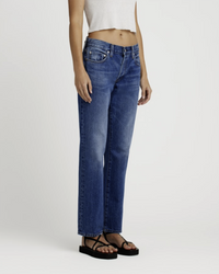 Woman wearing Edwin Simone in Idle midrise, straight leg blue jeans and black sandals with a white cropped top.