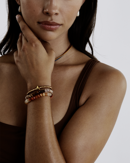 Woman with a Chan Luu CL Bracelet in Fire Opal posing with her hand on her chin.