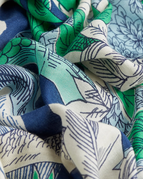 Close-up of an oversized bandana with a leaf pattern in shades of green and blue: Square 130 Robinson in Navy by Inoui Editions.