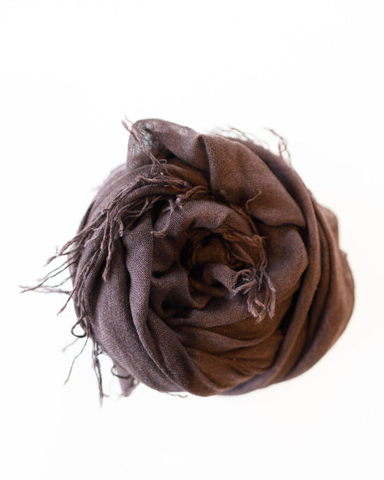 A rolled-up Chan Luu Cashmere & Silk Scarf in Java, featuring fringed trims, is luxuriously displayed from above on a white background.
