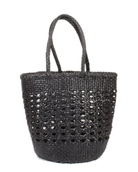 The Cannage Bucket - Big in Black by Dragon Diffusion is a black woven tote with two handles, featuring a stunning cannage weave and a solid base for durability.