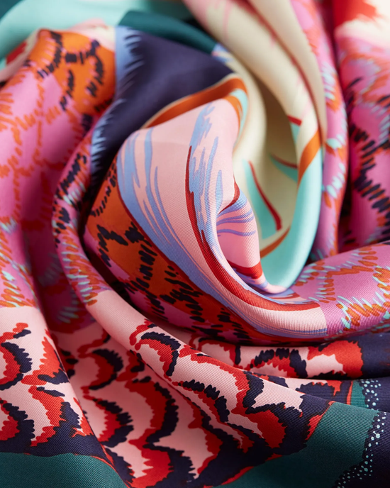 Inoui Editions Square 65 Toucan in Emerald silk scarf with colorful abstract pattern draped elegantly.