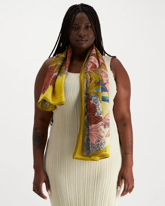 Woman posing with an oversized Square 130 Robinson in Yellow silk cashmere blend scarf draped over her shoulders from Inoui Editions.
